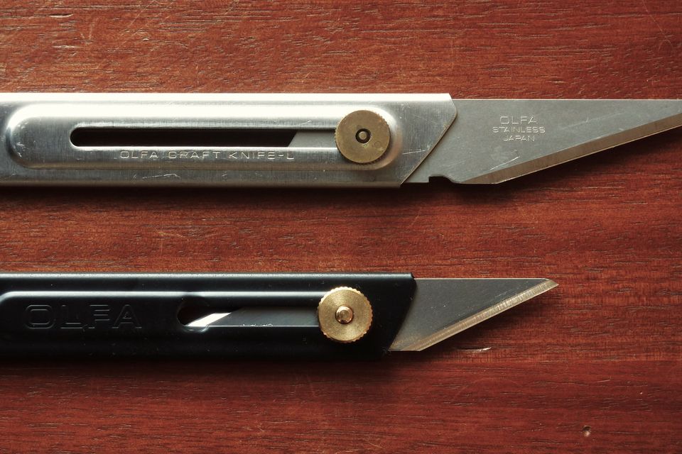 Two craft knives on a wooden table