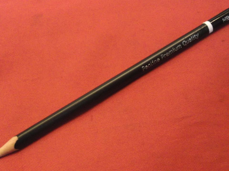 A pencil lying on a sheet of red paper