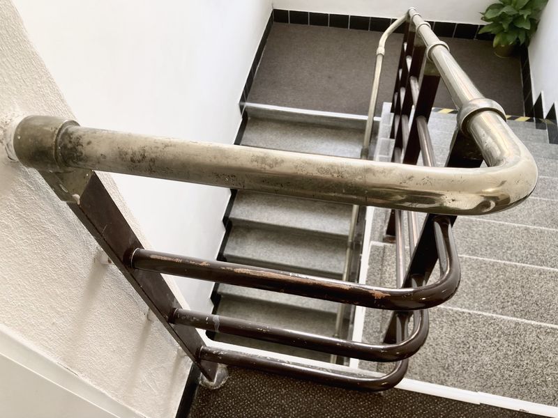 A staircase with a curved steel handrail