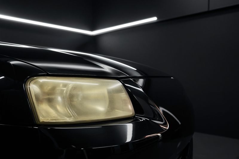 Hazed yellow headlight lens on a dark car