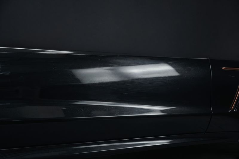 Dull black paint with swirl marks and dust