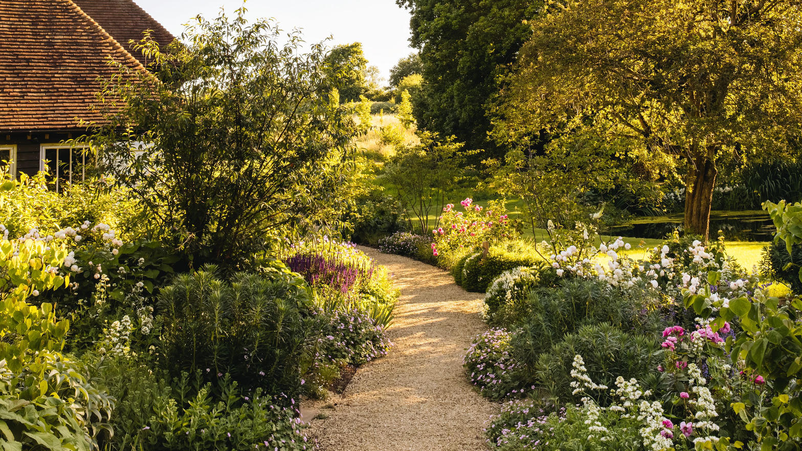 A gravel path through a layered cottage border