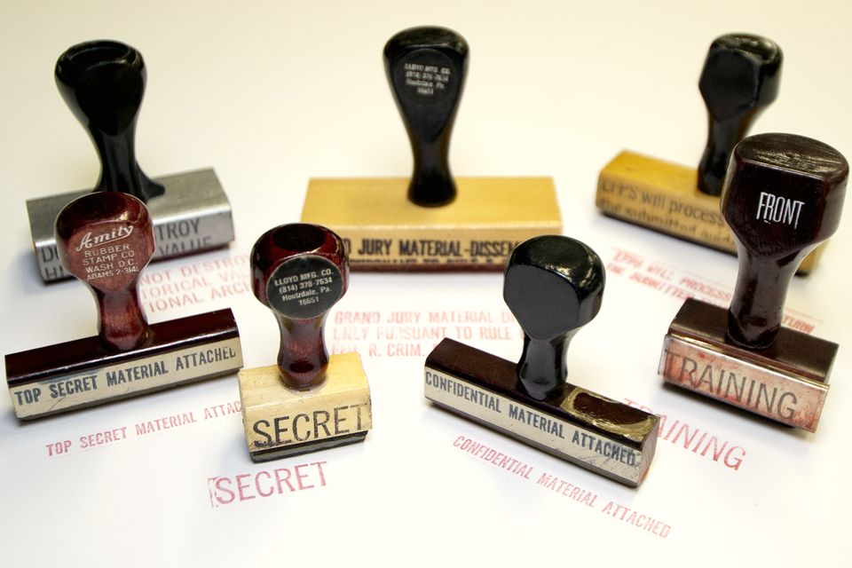 Six old rubber stamps with wooden handles on a white table