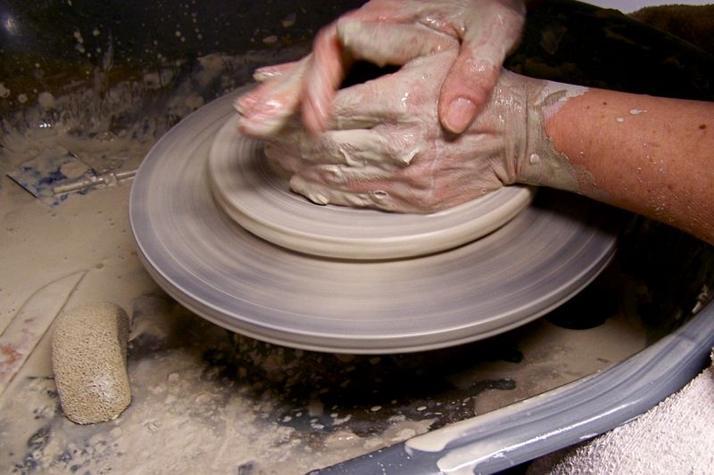 A potter shaping clay on a wheel