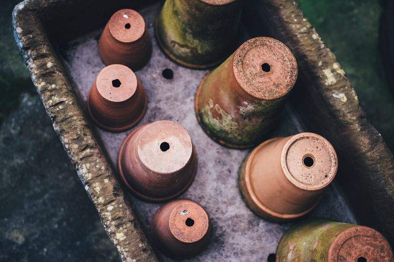Terracotta pots stacked on a wooden table