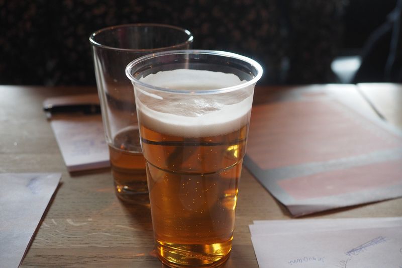 Glasses of beer and answer papers on a table at a pub quiz