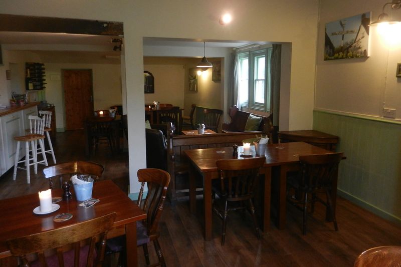 Wooden tables and chairs in a bright pub dining room