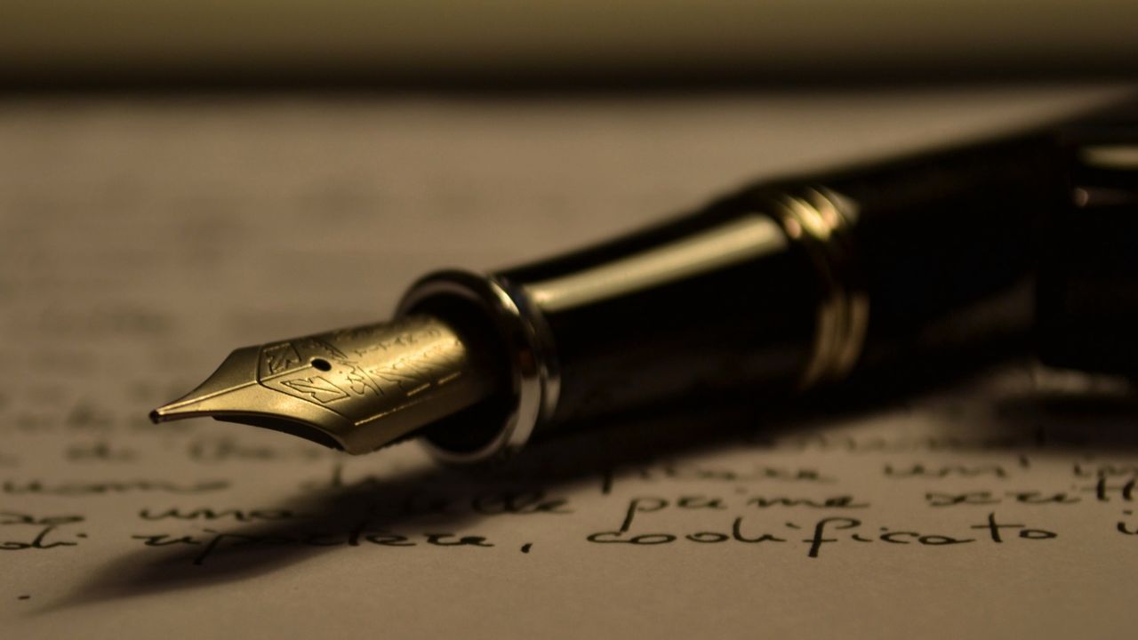 A fountain pen lying across a handwritten page