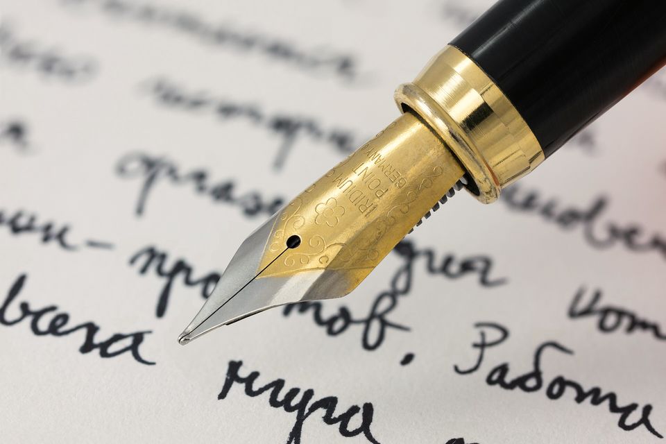 A gold fountain-pen nib writing a line of script
