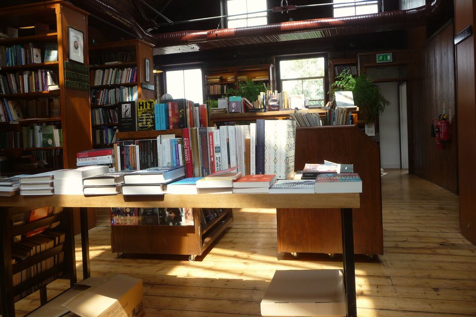 Inside a secondhand bookshop: tall shelves and a table of books