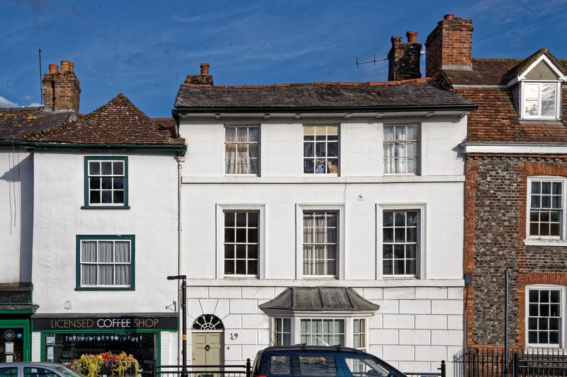 Georgian high street with white-painted shopfronts and brick townhouses