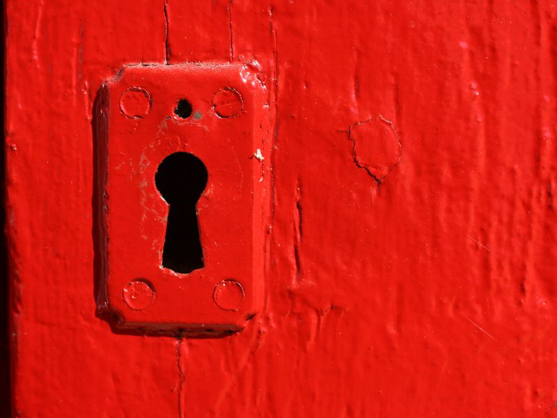 Old keyhole plate on a door painted bright red