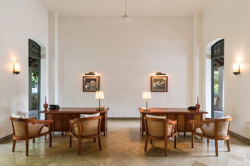 Bright reception room with wooden tables, leather chairs and tall windows