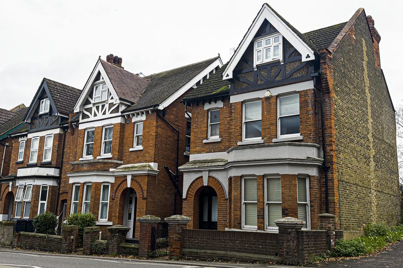 Row of Victorian red-brick terraced houses with gabled bay windows