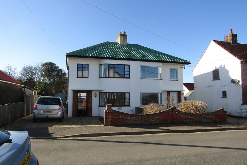1930s Art Deco style semi-detached house with white render, a green tiled roof and a front drive