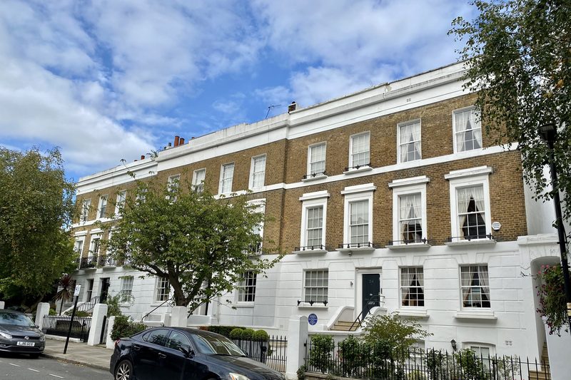 Terrace of white stucco and brick townhouses with iron balconies and front railings