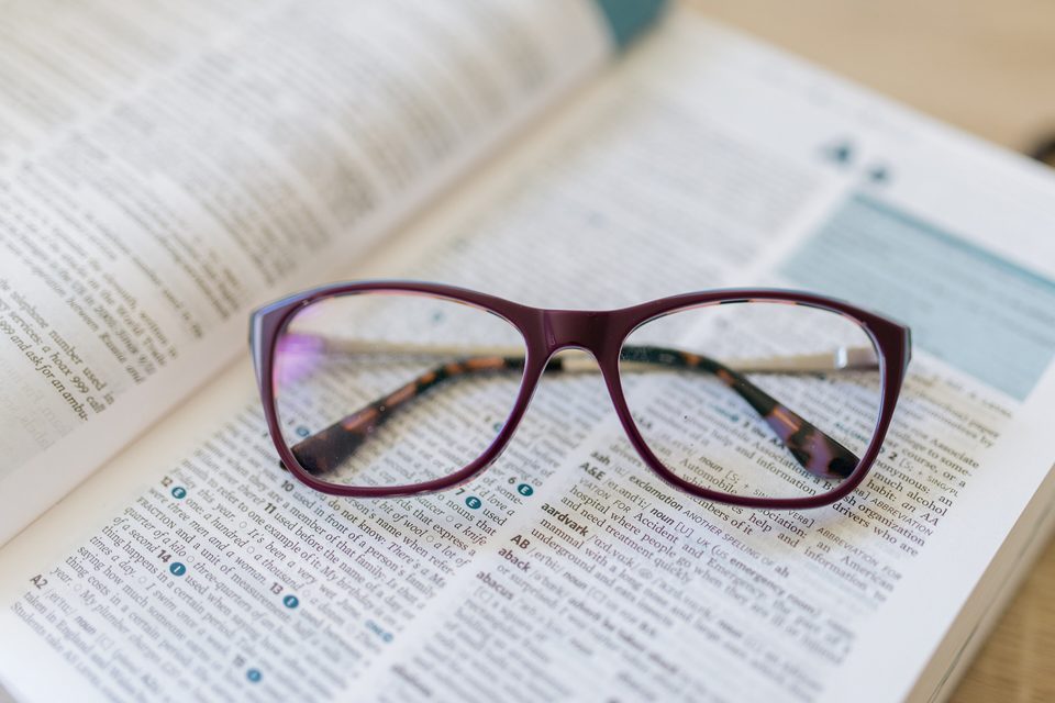 Reading glasses resting on an open book