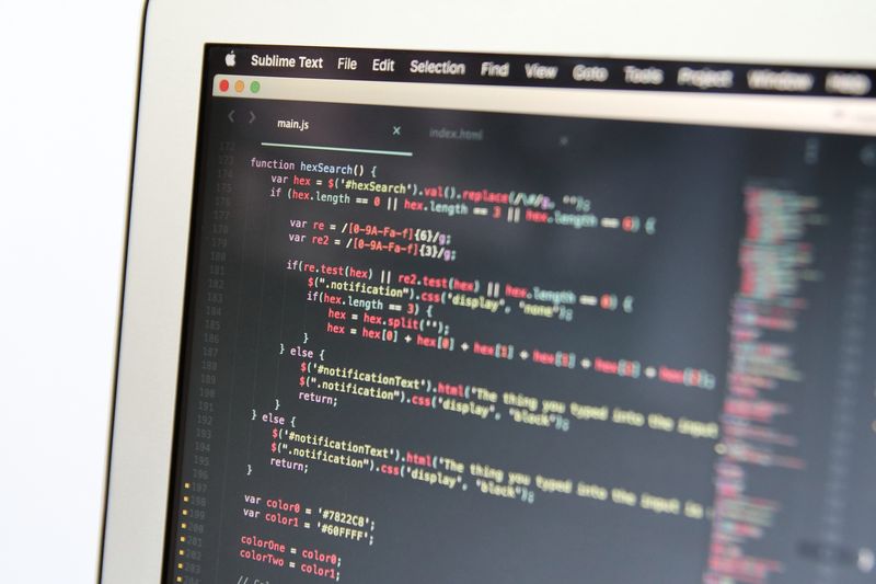 A laptop screen showing lines of code in a dark code editor