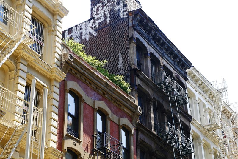 Cast-iron building facades with fire escapes on a street in SoHo, New York