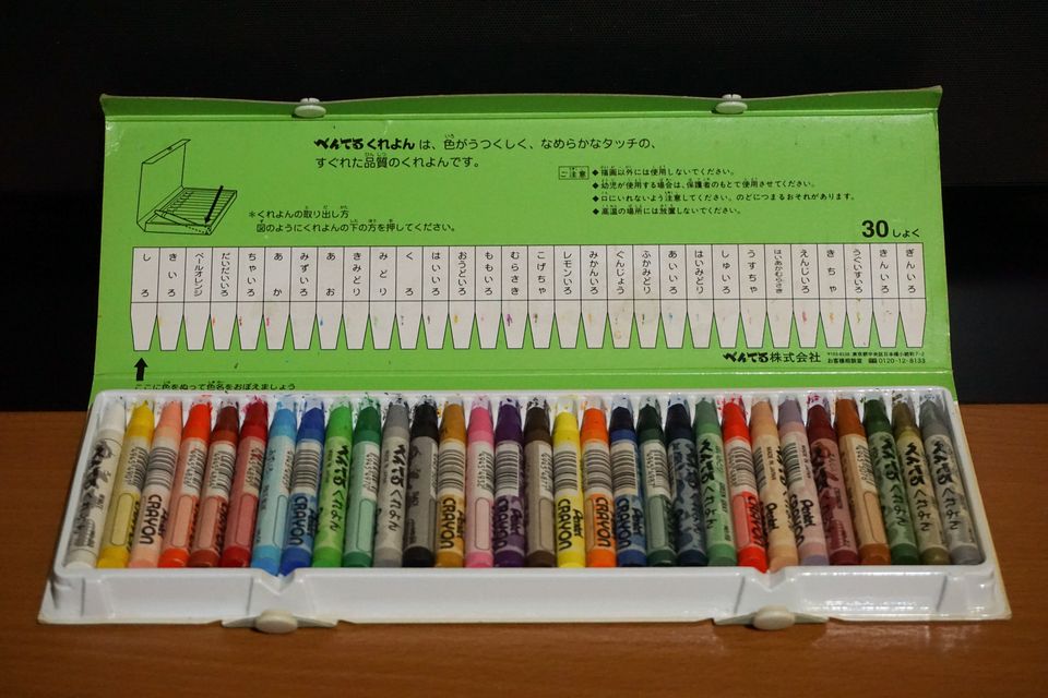 A box of thirty wax crayons in a row of colours