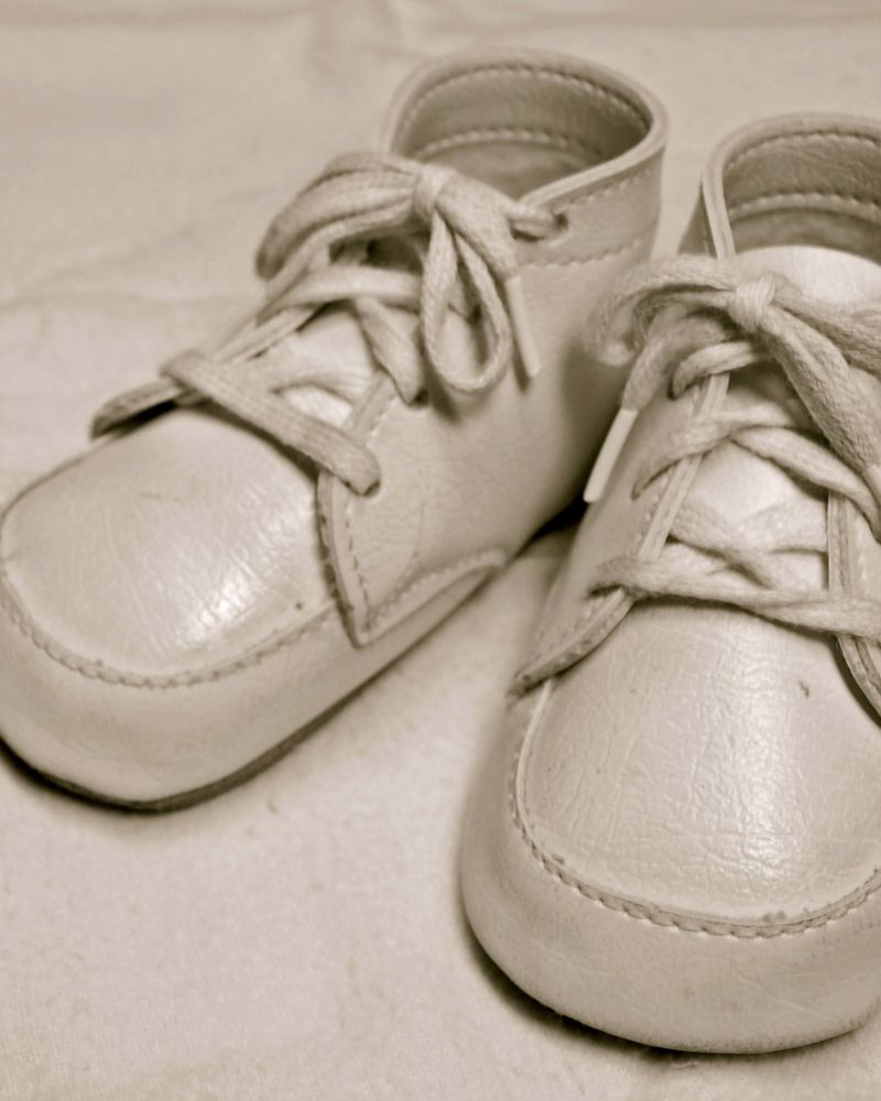A pair of white leather baby shoes