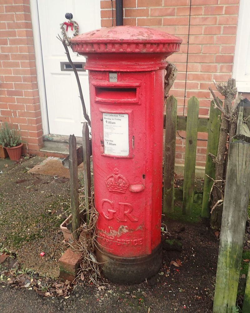 A red pillar box on a quiet residential corner