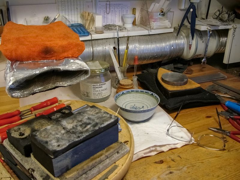 A jeweller’s cluttered workbench with pliers, files and small hand tools