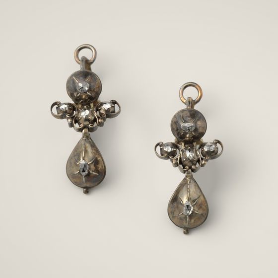 A pair of silver drop earrings set with rose-cut diamonds, on pale grey, library photograph shown for style