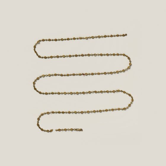 A long gold chain laid in rows, on pale grey, library photograph shown for style