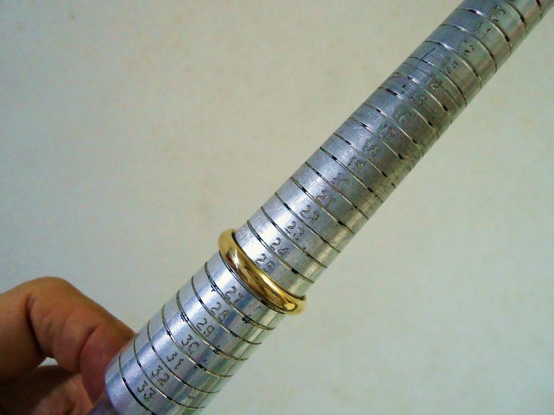 A gold ring sitting on a steel ring mandrel