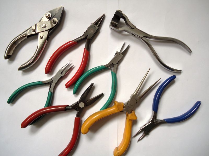 A set of jeweller’s pliers laid out on a white surface