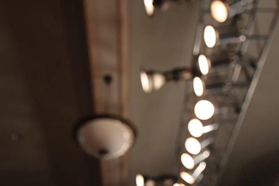 A row of bare light bulbs hanging from a ceiling, out of focus at the edges