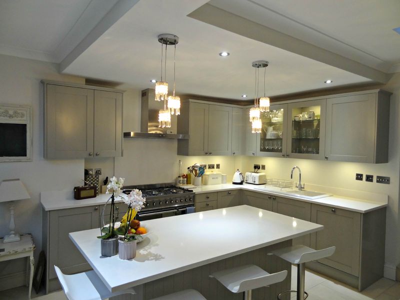 A painted grey shaker-style kitchen with an island and wall cabinets