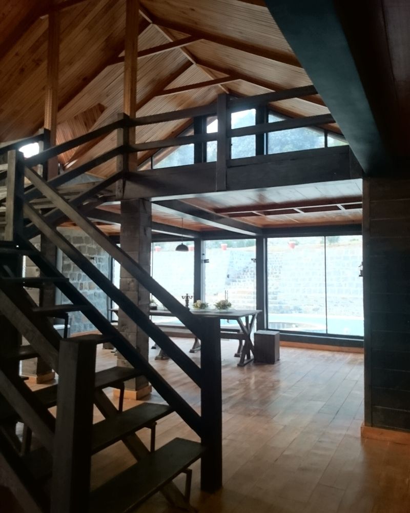 An open timber staircase rising beside a double-height window