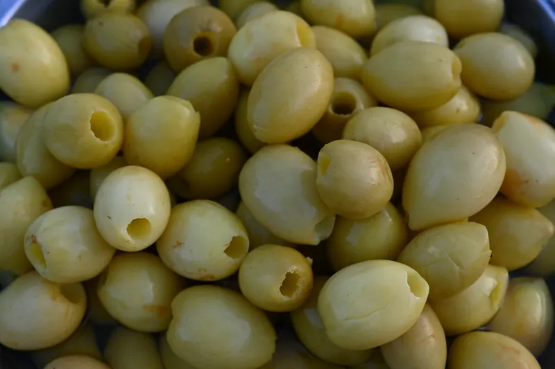 A close-up of pitted green olives