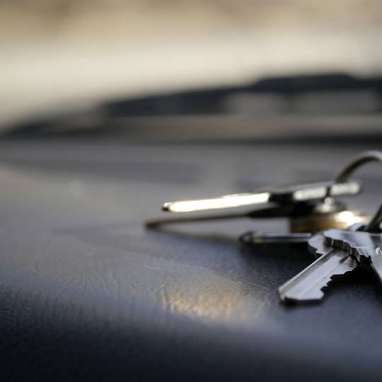 A small bunch of keys resting on a car dashboard.