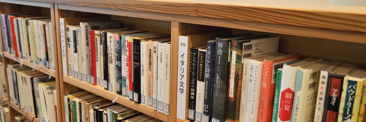 Long wooden shelves packed with books