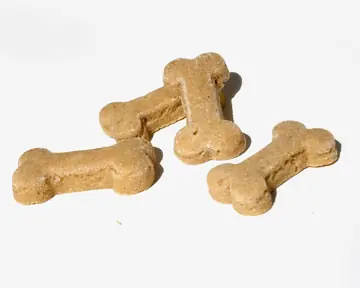 Three bone-shaped dog biscuits on a white surface