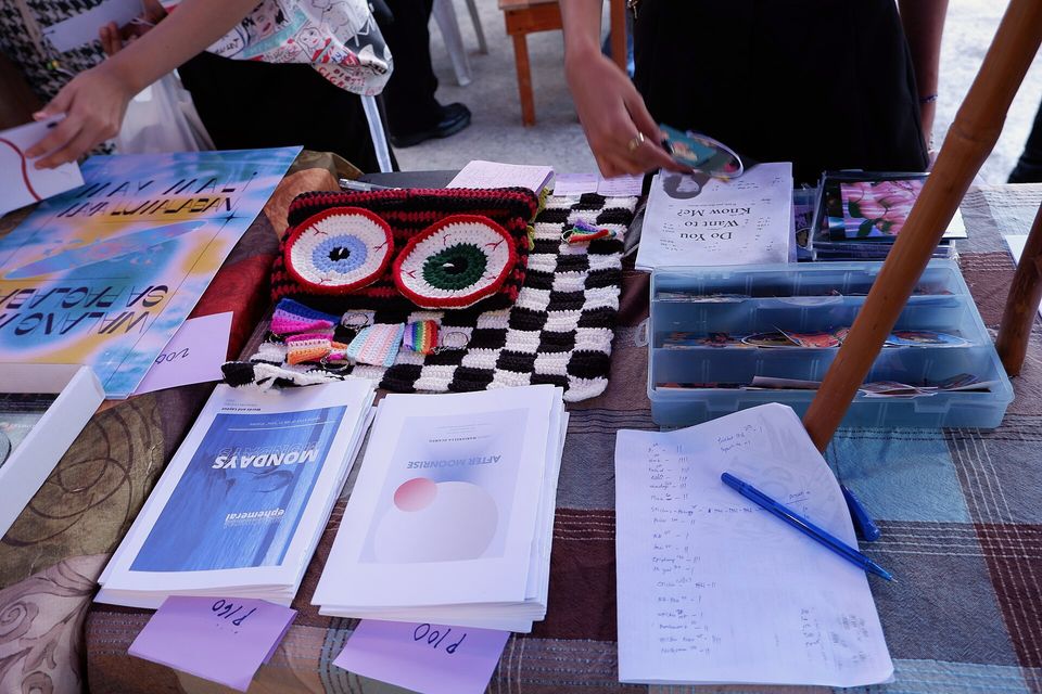Hand-printed zines and booklets spread on a table at a small press fair
