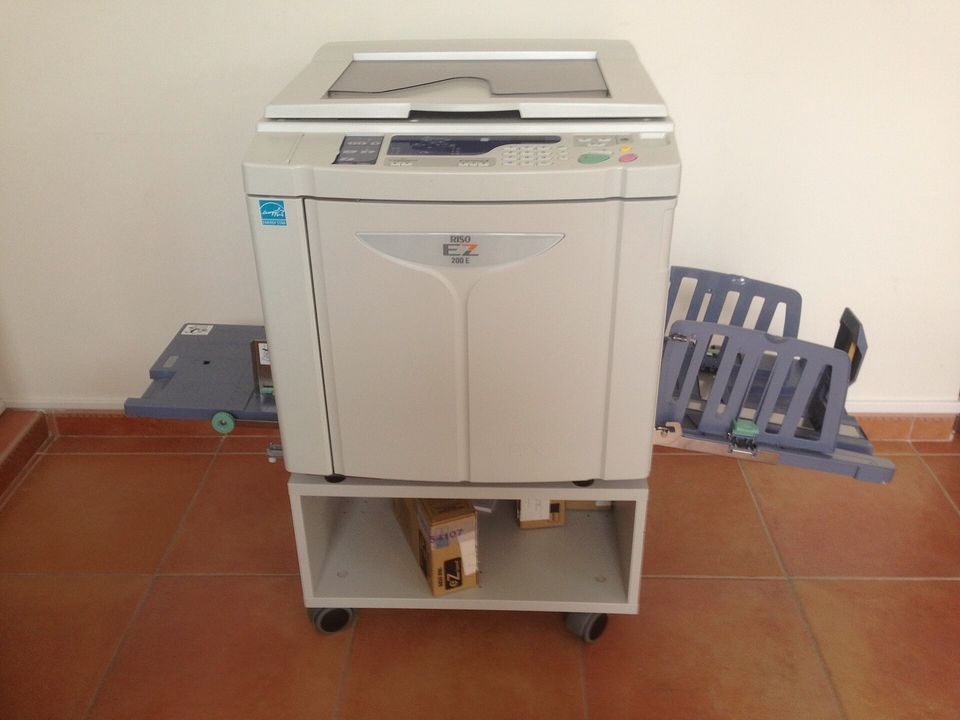 A risograph duplicator in a print room, paper trays out at both sides