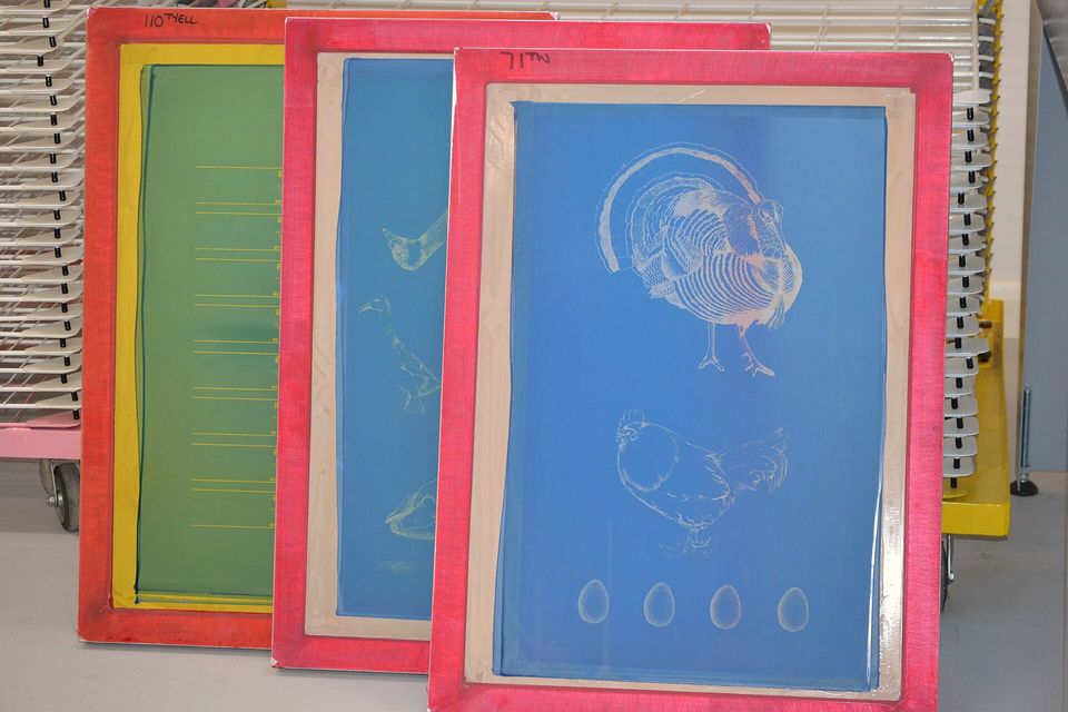 Exposed silk screens in yellow, red and blue frames leaning side by side