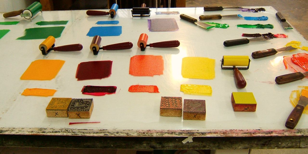 Rows of mixed ink swatches in orange, red, yellow and brown on a white bench