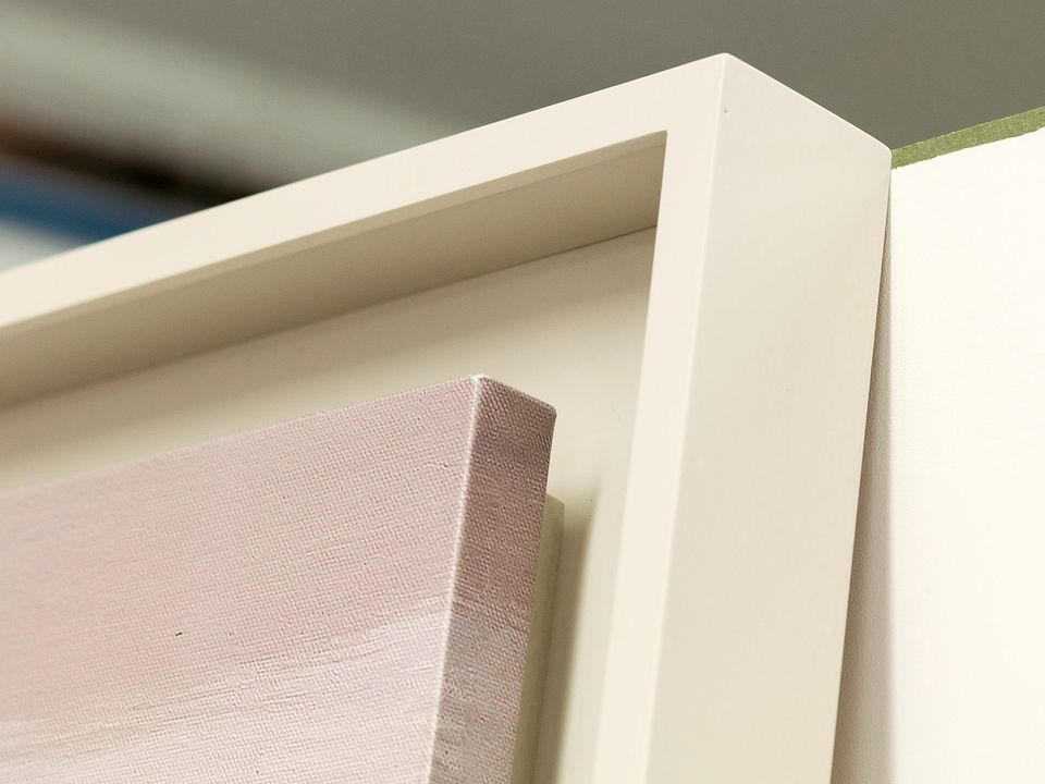 The corner of a white tray frame with a deep, shadowed edge