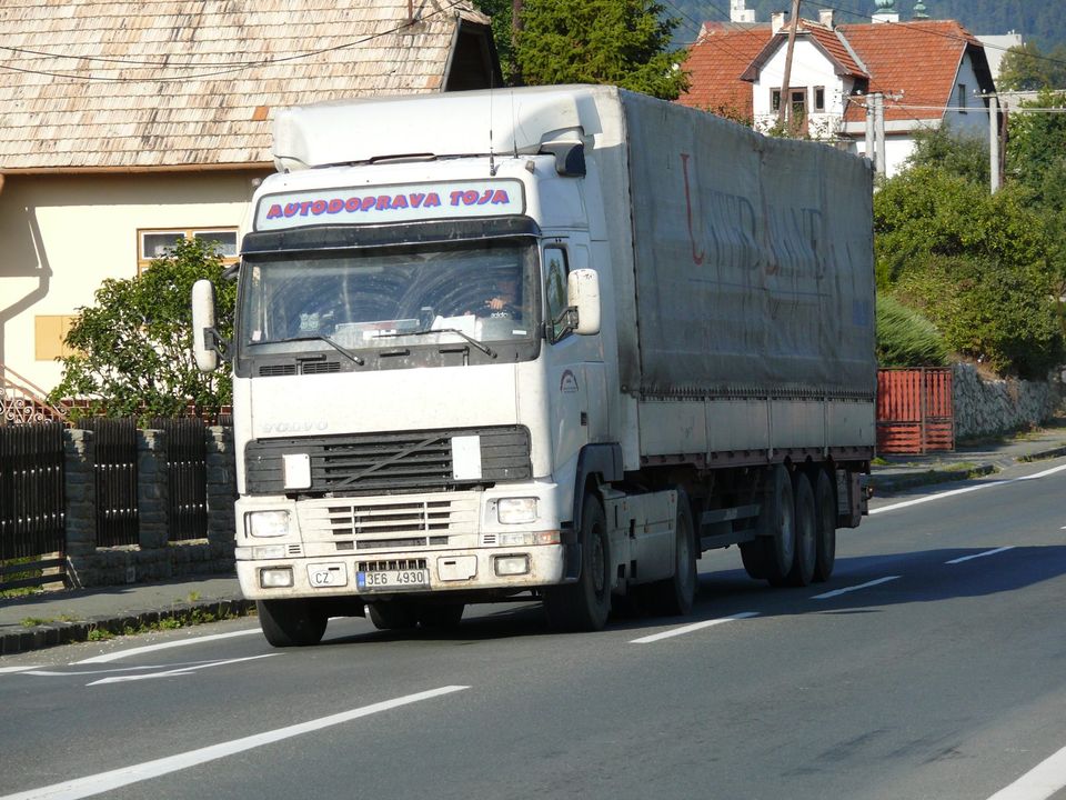 Articulated lorry with a curtain-sided trailer on a village road