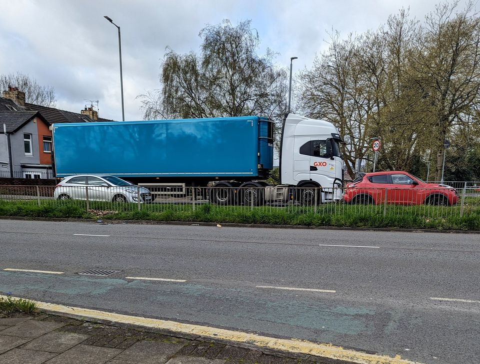 Blue curtain-sided articulated lorry on a town road