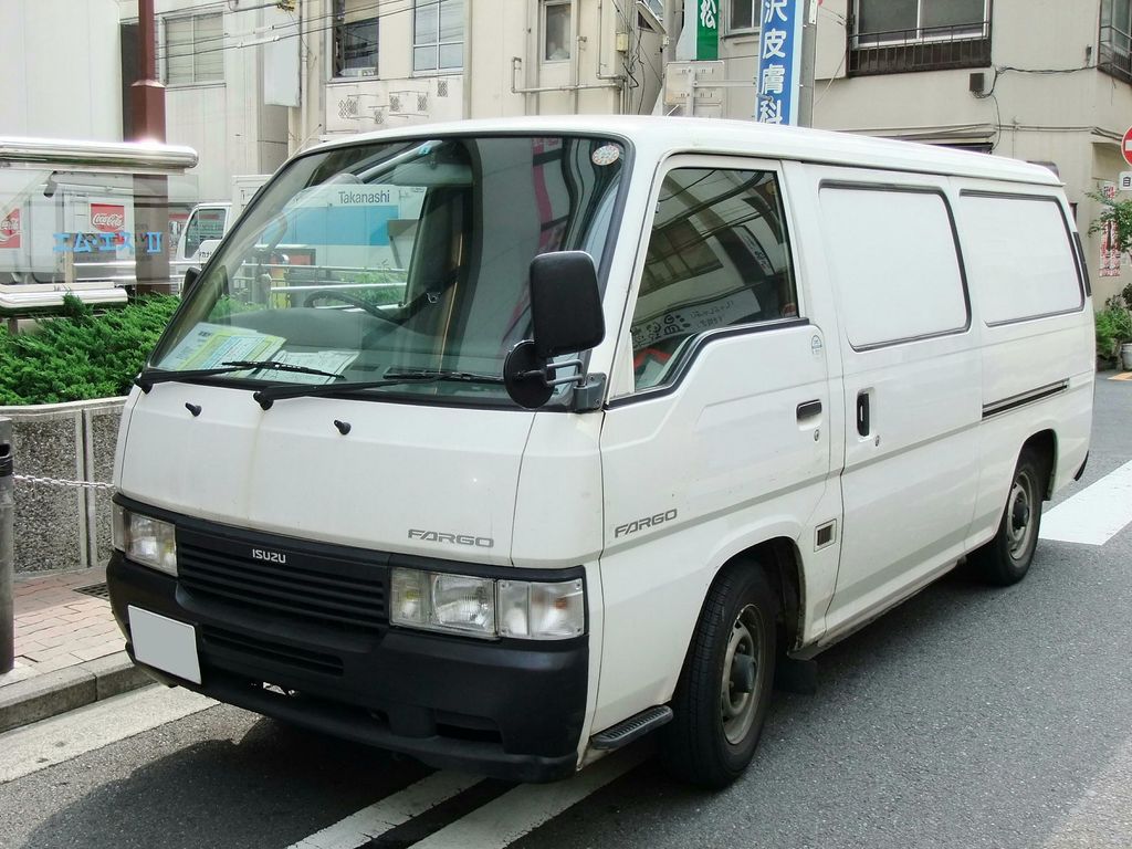 A white panel van parked at the kerb on a city street