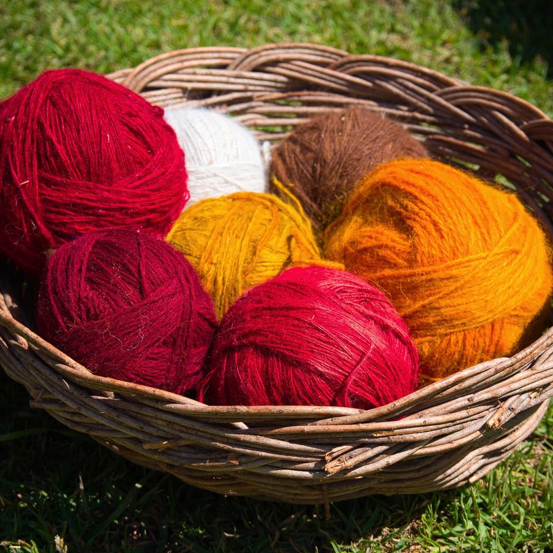 Balls of red, orange and cream alpaca yarn in a wicker basket