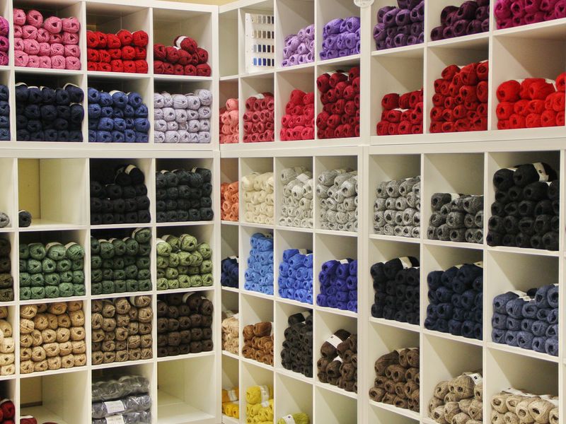 Wooden cubby shelves stacked with wool in many colours