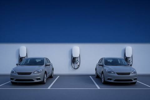 Communal parking bays with wall chargers on a pale boundary wall.