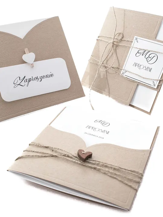 Kraft paper wedding invitations tied with twine and a small wooden heart